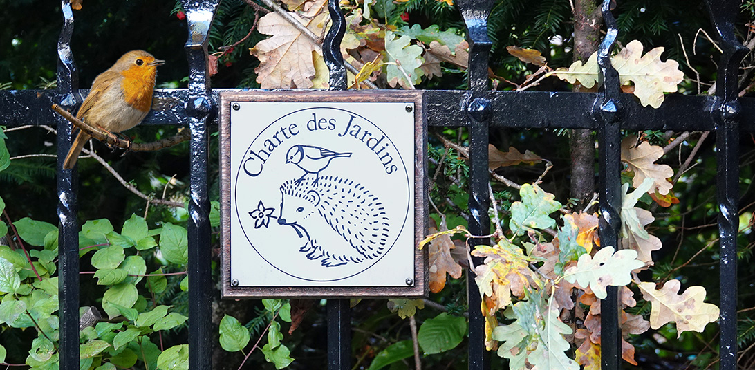 Emblème de la Charte des Jardins sur une barrière